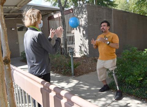 With physical therapist Karen Klein, at left, J. Carmen Arevalo worked on complex tasks while using his prosthesis, like stepping side-to-side while throwing and catching a ball, at Methodist Outpatient Therapy in Flowood.