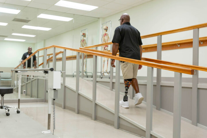 Patient walking up a ramp at one of our Orthotics and Prosthetics clinics