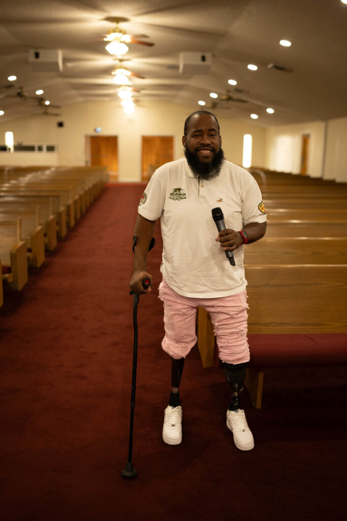 Christopher Williams poses in a church with a microphone