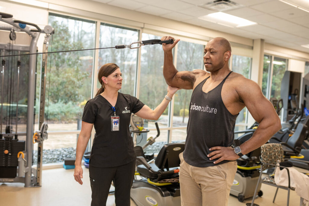 Therapist works with a patient doing strength training