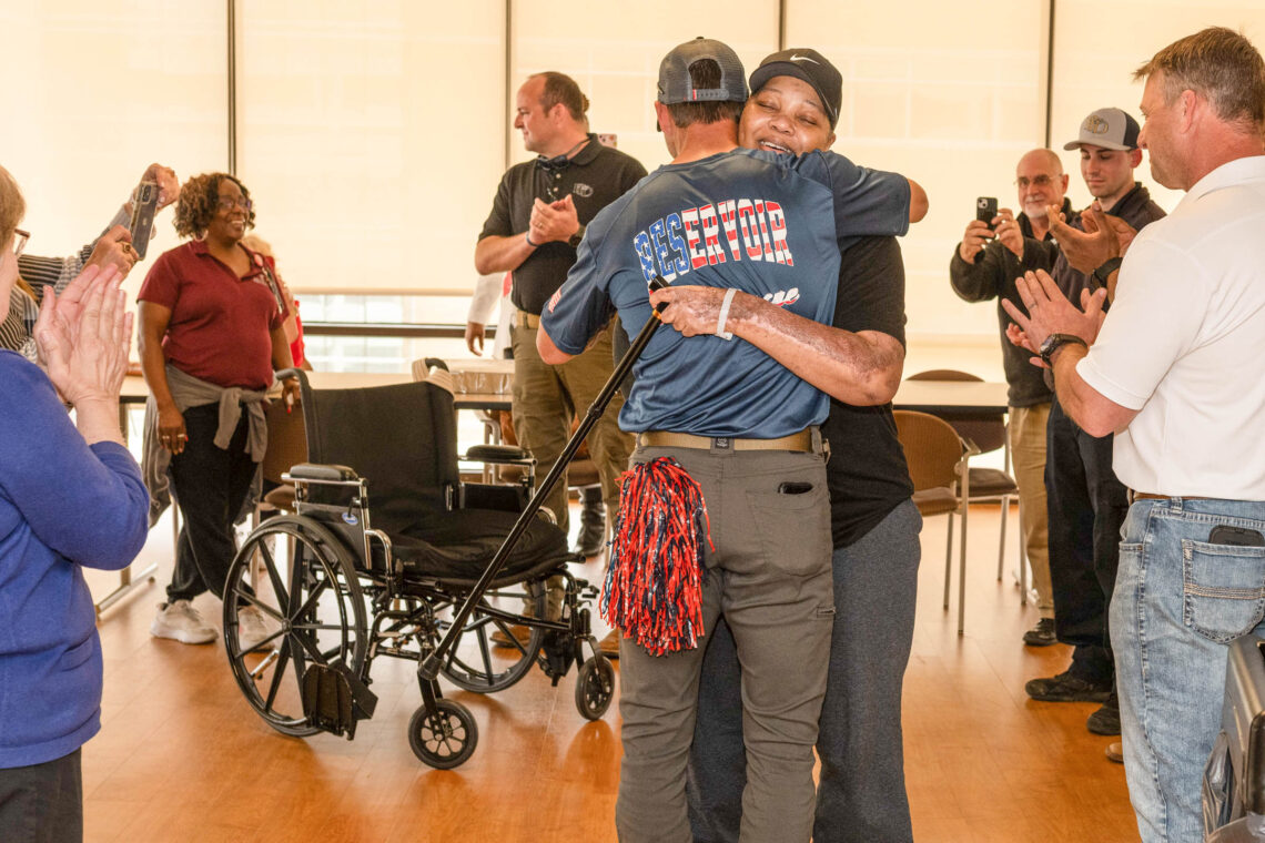 Cynthia Fomby stands and hugs family & staff