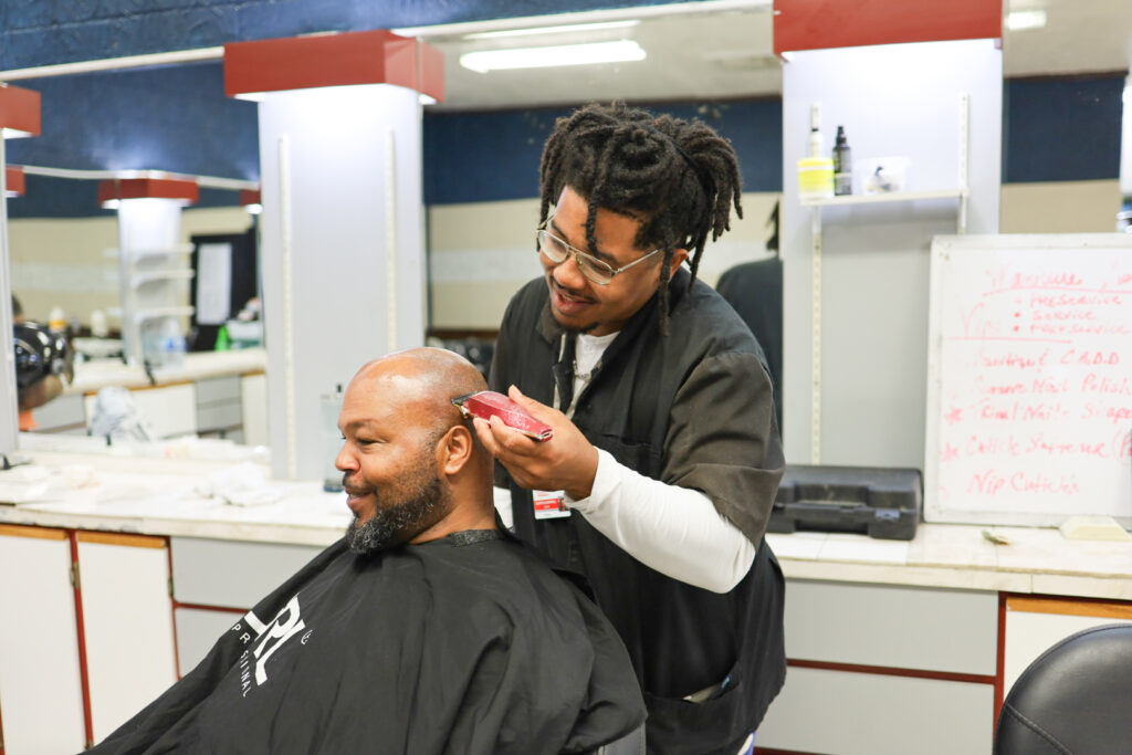 Patient Curtis Gainwell giving a man a haircut