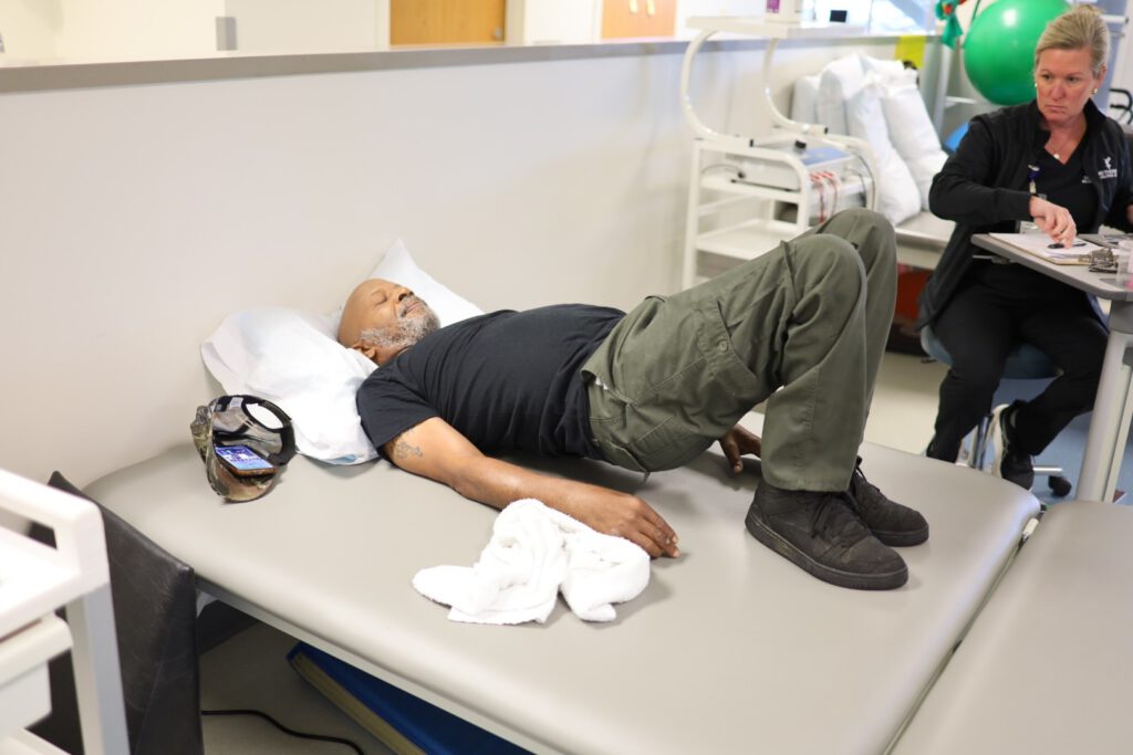 Michael Johnson stretches his back during outpatient therapy