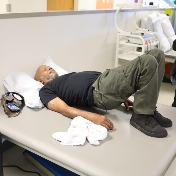 Michael Johnson stretches his back during outpatient therapy
