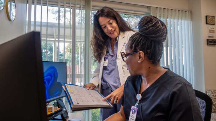 Multiple Methodist Rehabilitation team members discuss a patient file