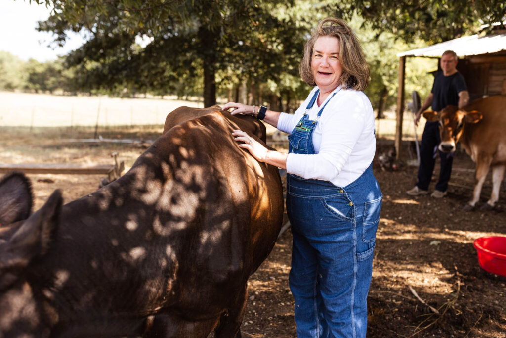 Amy Degrado poses next to one of her cows on the farm