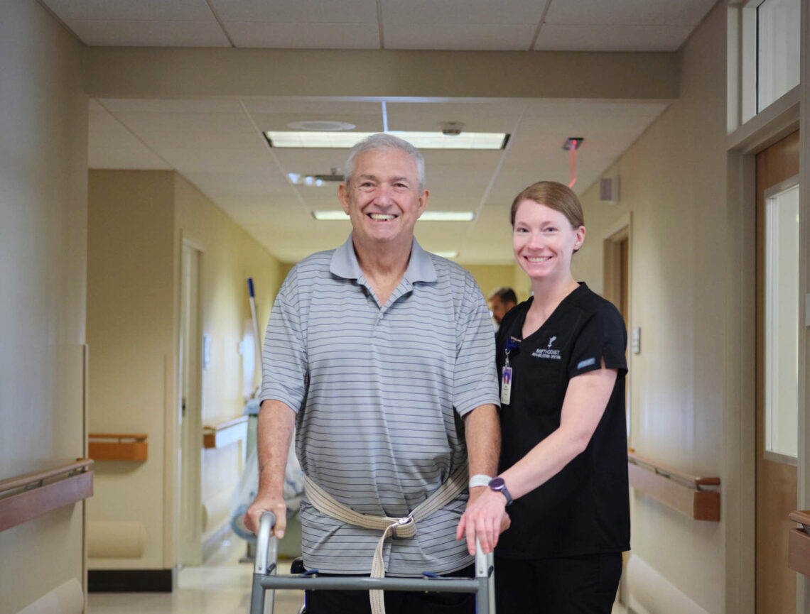 Smiling patient in a walker with a therapist